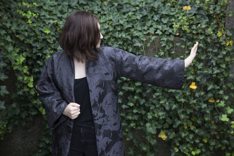 Woman wearing midi length black open front jacket